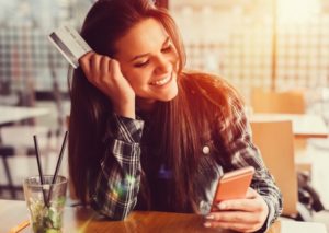 Young women in a cafe with credit card +++++ Note for the inspector : Credit card is fake +++++